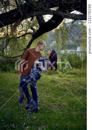 15-year-old teenage couple in love walks through the park on a cold autumn evening 128276598