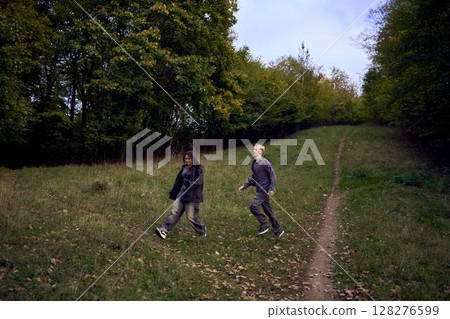 two 15-year-old teenagers in love play, hug, spend time together in an autumn park 128276599