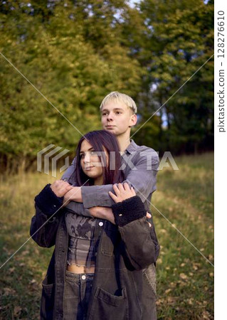 two 15-year-old teenagers in love play, hug, spend time together in an autumn park two 15-year-old teenagers in love play, hug, spend time together in an autumn park 128276610