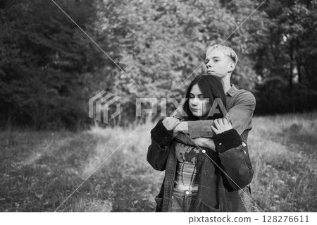 two 15-year-old teenagers in love play, hug, spend time together in an autumn park two 15-year-old teenagers in love play, hug, spend time together in an autumn park 128276611