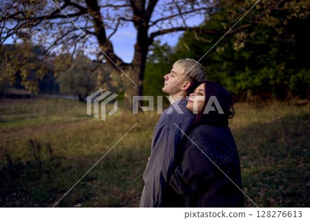 two 15-year-old teenagers in love play, hug, spend time together in an autumn park two 15-year-old teenagers in love play, hug, spend time together in an autumn park 128276613