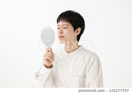 Man looking in a hand mirror Man looking in a hand mirror 128277597