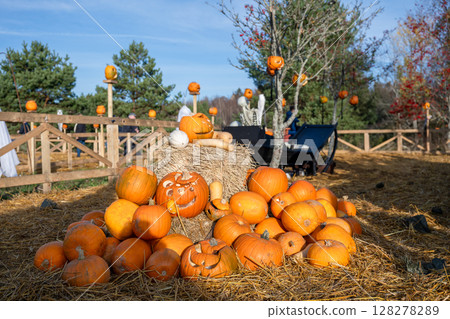 Pile of pumpkins and hay in festive Halloween setup Pile of pumpkins and hay in festive Halloween setup 128278289