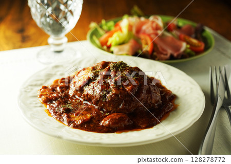 Braised hamburger steak with mushrooms and demi-glace sauce and prosciutto salad 128278772