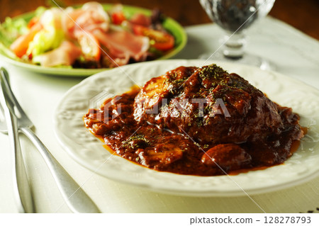 Braised hamburger steak with mushrooms and demi-glace sauce and prosciutto salad 128278793