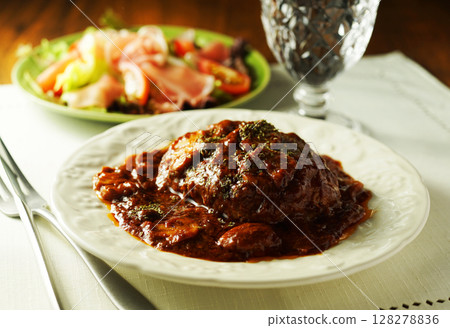 Braised hamburger steak with mushrooms and demi-glace sauce and prosciutto salad 128278836