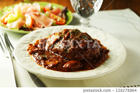 Braised hamburger steak with mushrooms and demi-glace sauce and prosciutto salad 128278864