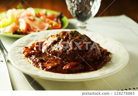 Braised hamburger steak with mushrooms and demi-glace sauce and prosciutto salad 128278865
