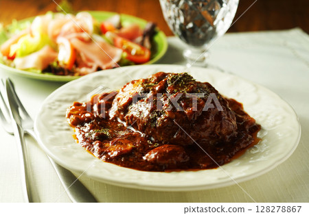 Braised hamburger steak with mushrooms and demi-glace sauce and prosciutto salad 128278867