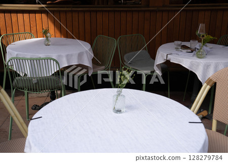 Charming Outdoor Caf Setting with Green Chairs 128279784
