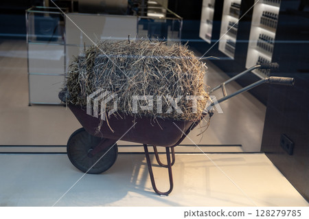 A Rustic Wheelbarrow that is Overflowing with Freshly Gathered Hay from the Farm A Rustic Wheelbarrow that is Overflowing with Freshly Gathered Hay from the Farm 128279785