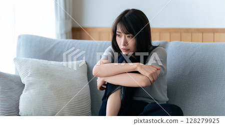 一位女士坐在沙發上思考 128279925