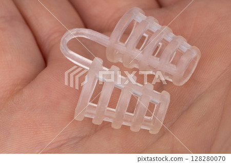 Silicone anti snoring nose clip in hand 128280070