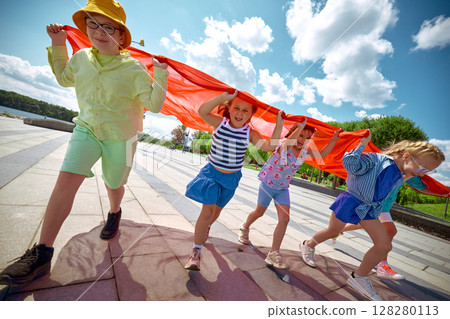 Kids gleefully playing beneath a clear blue sky outside Kids gleefully playing beneath a clear blue sky outside 128280113