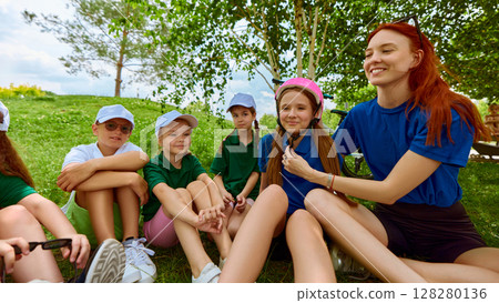 Safety first. Teacher showing kids how to wear a helmet 128280136
