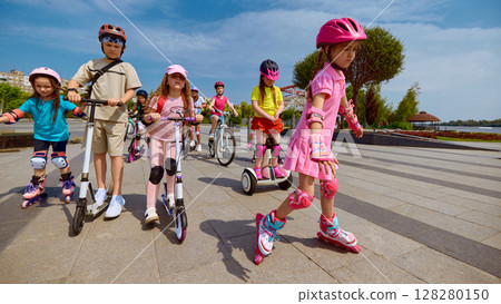 Color parade. Children having fun outside with scooters and rollerblades on a sunny day Color parade. Children having fun outside with scooters and rollerblades on a sunny day 128280150