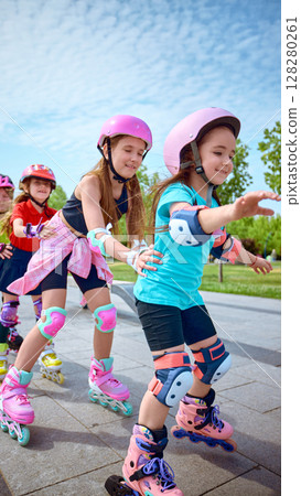 Joyful kids rollerblading in park on sunny day 128280261