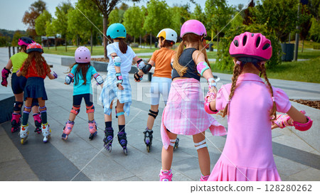 Kids skating in park using vibrant safety gear Kids skating in park using vibrant safety gear 128280262
