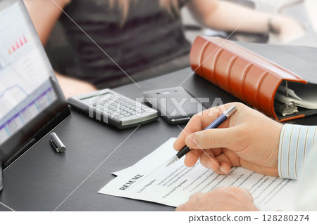Job Interview in the office with focus on resume and pen Job Interview in the office with focus on resume and pen 128280274