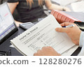 Businessman with pen analyzing  financial documents  in the office  128280276