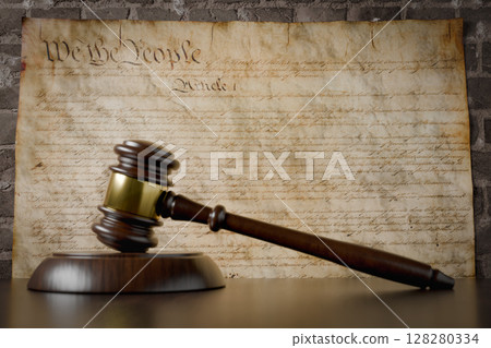 United States Constitution On Wall with Gavel Resting on Table in Front. 128280334