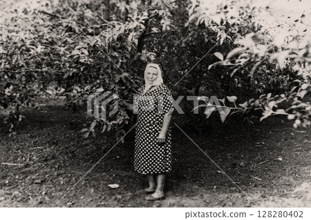 Vintage portrait of a woman in a summer garden. Retro photo 1960. Apolonovka, Kharkov, Ukraine. 128280402