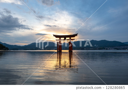 Famous red torii gate of Itsukushima shrine at sunset in Miyajima, Japan 128280865