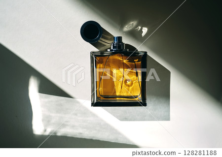 A golden bottle of perfume in a sunbeam. A golden bottle of perfume in a sunbeam. 128281188
