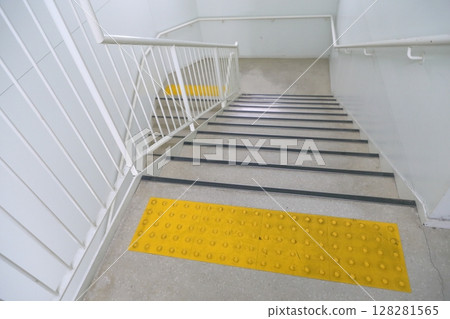 Emergency stairs in a building: Braille blocks in front of the stairs 128281565
