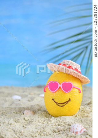 Creative minimal summer idea. Lemon citrus hipster in pink sunglasses and bamboo hat on sand. Tropical beach concept. Creative art. Copy space Creative minimal summer idea. Lemon citrus hipster in pink sunglasses and bamboo hat on sand. Tropical beach concept. Creative art. Copy space 128281724