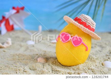 Creative minimal summer idea. Lemon citrus hipster in bamboo hat, sunglasses and beach umbrella on sand. Tropical beach concept. Creative art. Copy space 128281744