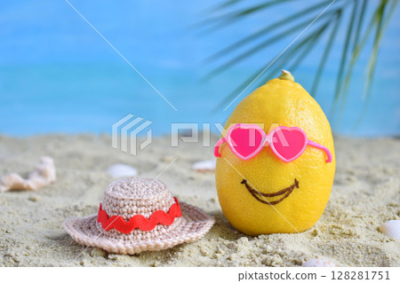 Creative minimal summer idea. Lemon citrus hipster in pink sunglasses and bamboo hat on sand. Tropical beach concept. Creative art. Fun party Mood. Copy space Creative minimal summer idea. Lemon citrus hipster in pink sunglasses and bamboo hat on sand. Tropical beach concept. Creative art. Fun party Mood. Copy space 128281751