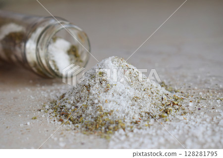 Ayurvedic herbal salt in glass jar. Sea salt with aromatic herb - rosemary, oregano, sage, marjoram, basil, thyme, mint, bay leaf. Copy space 128281795