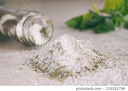 Ayurvedic herbal salt in glass jar. Sea salt with aromatic herb - rosemary, oregano, sage, marjoram, basil, thyme, mint, bay leaf. Copy space 128281796