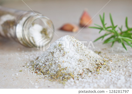 Herbal salt in glass jar. Sea salt with aromatic herb - rosemary and garlic. Copy space 128281797