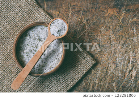 Ayurvedic herbal salt in wooden spoon. Sea salt with aromatic herb - rosemary, oregano, sage, marjoram, basil, thyme, mint, bay leaf. Copy space Ayurvedic herbal salt in wooden spoon. Sea salt with aromatic herb - rosemary, oregano, sage, marjoram, basil, thyme, mint, bay leaf. Copy space 128281806