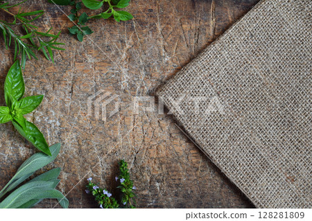 Fresh spicy and medicinal herbs on wooden background. Border from various herb - rosemary, oregano, sage, marjoram, basil, thyme, mint. Food frame for recipe 128281809