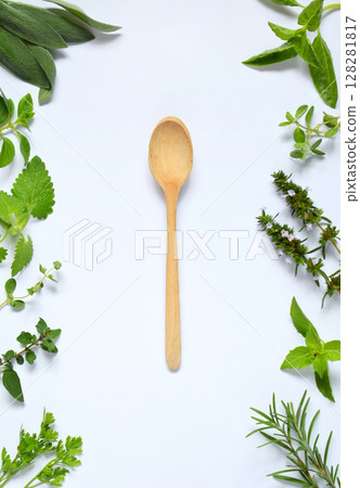 Fresh spicy and medicinal herbs on white background and wooden spoon. Border from various herb - rosemary, oregano, sage, marjoram, basil, thyme, mint. Food frame for recipe 128281817