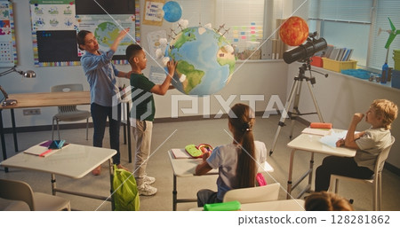 STEM Class: Female Teacher Teaches Renewable Energy to Elementary School Kids in Classroom 128281862