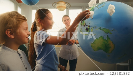 STEM Class: Talented Girl Presenting Green Energy Sources Using Earth Model 128281882