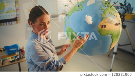 Female School Teacher Educating Science and Renewable Energy Sources Using Model of Planet Earth Female School Teacher Educating Science and Renewable Energy Sources Using Model of Planet Earth 128281903
