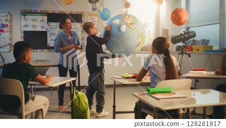 Primary School Boy Presenting Green Energy Sources in Front of Class Using Earth Model 128281917