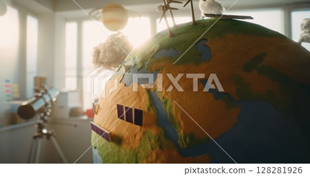 Globe with Miniature 3D Models of Wind Turbines and Solar Panels for Studying Green Energy 128281926