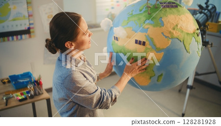 Female School Teacher Educating Science and Renewable Energy Sources Using Model of Planet Earth Female School Teacher Educating Science and Renewable Energy Sources Using Model of Planet Earth 128281928