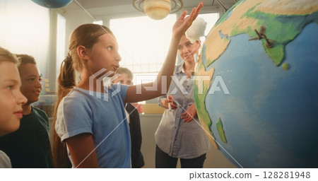 STEM Science Lesson: Smart School Girl Presenting Renewable Energy Sources Using Globe 128281948