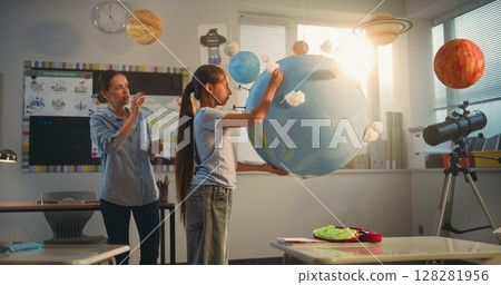 STEM Class: School Girl Presenting Renewable Energy Sources Using Model of Earth 128281956