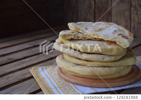 Pile of homemade flat bread on a wooden background. Mexican flatbread taco. Indian Naan. Space for text 128281988