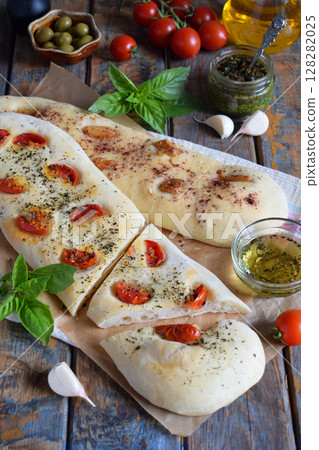 Traditional Italian Focaccia with tomatoes, basil, garlic and sumach. Homemade pastry. Flat bread. Organic flatbread. Rustic style. 128282025