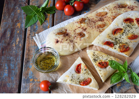 Traditional Italian Focaccia with tomatoes, basil, garlic and sumach. Homemade pastry. Flat bread. Organic flatbread. Rustic style. 128282029
