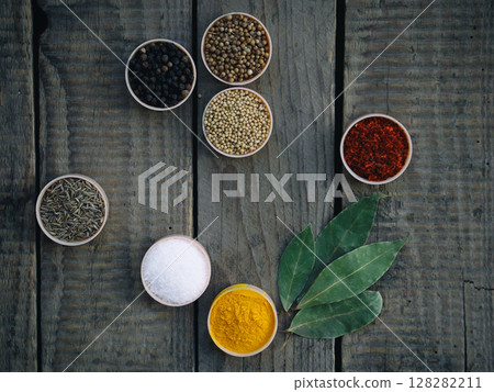 spices on a wooden background. Coriander, black pepper, paprika, mustard, turmeric, cumin. Mix for barbecue. 128282211
